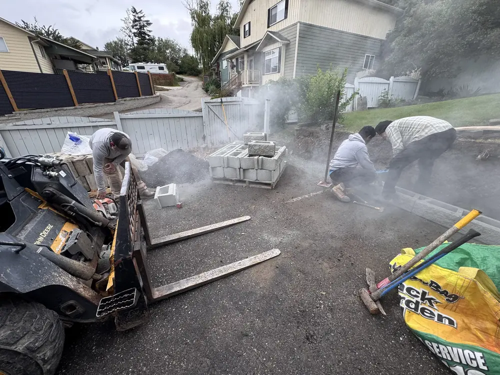 Crew cutting blocks during retaining wall and site restoration work